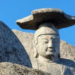 Close-up of the ancient Gatbawi Buddha statue in South Korea against a clear blue sky.