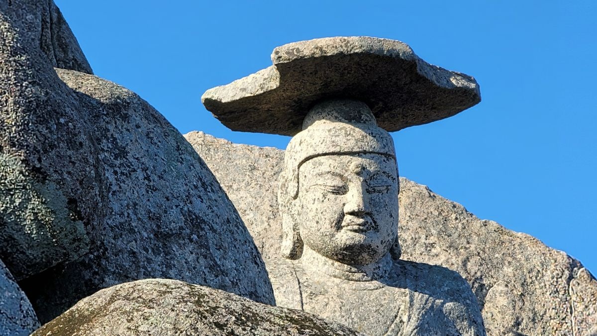 Close-up of the ancient Gatbawi Buddha statue in South Korea against a clear blue sky.